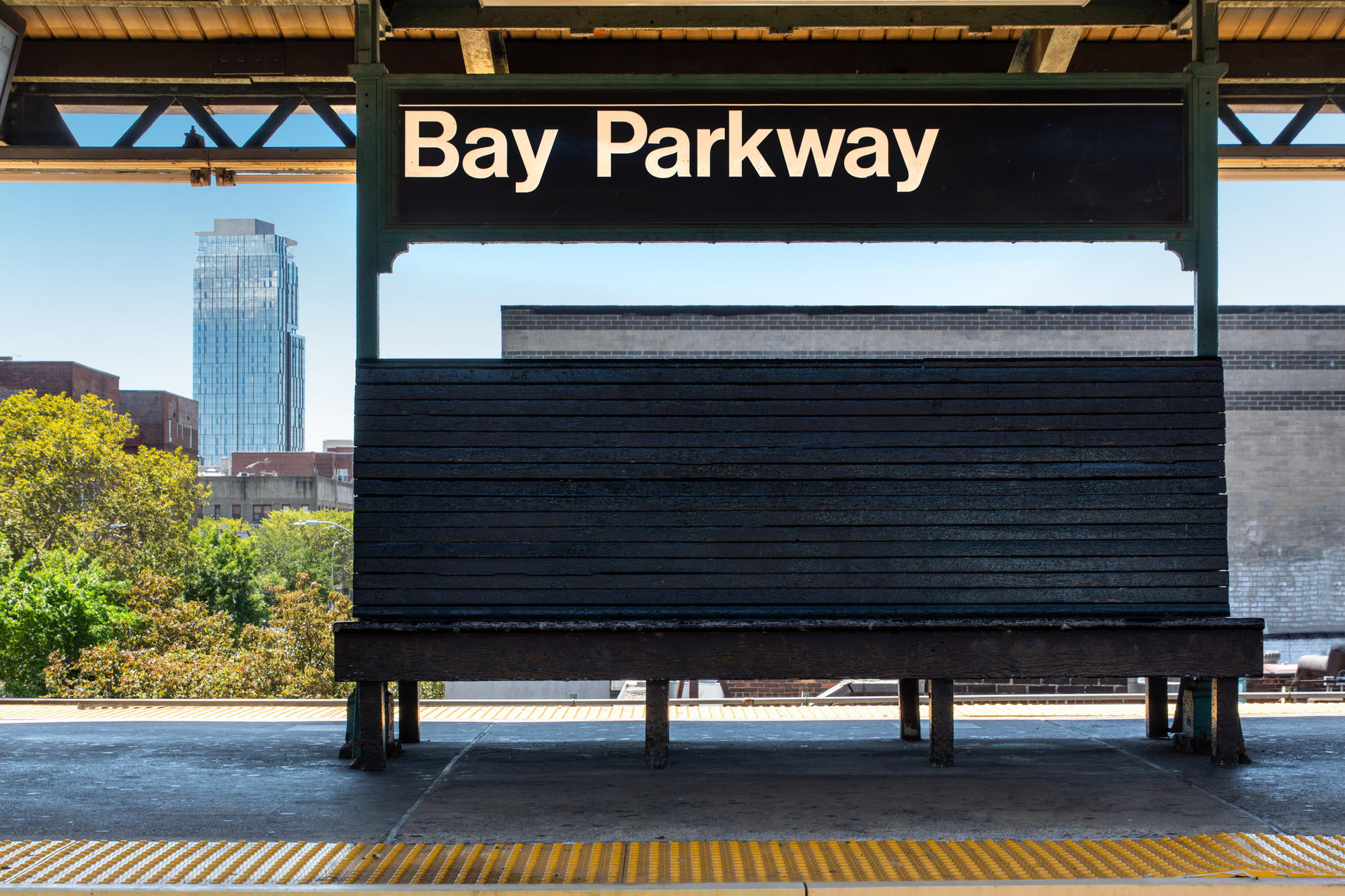 Bay Parkway sign above bench at subway stop